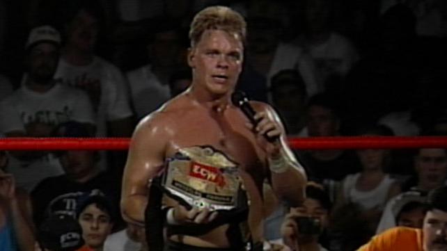 Shane Douglas presents the ECW World Heavyweight title to the crowd, microphone in hand as he cuts his infamous shoot promo on the NWA.
